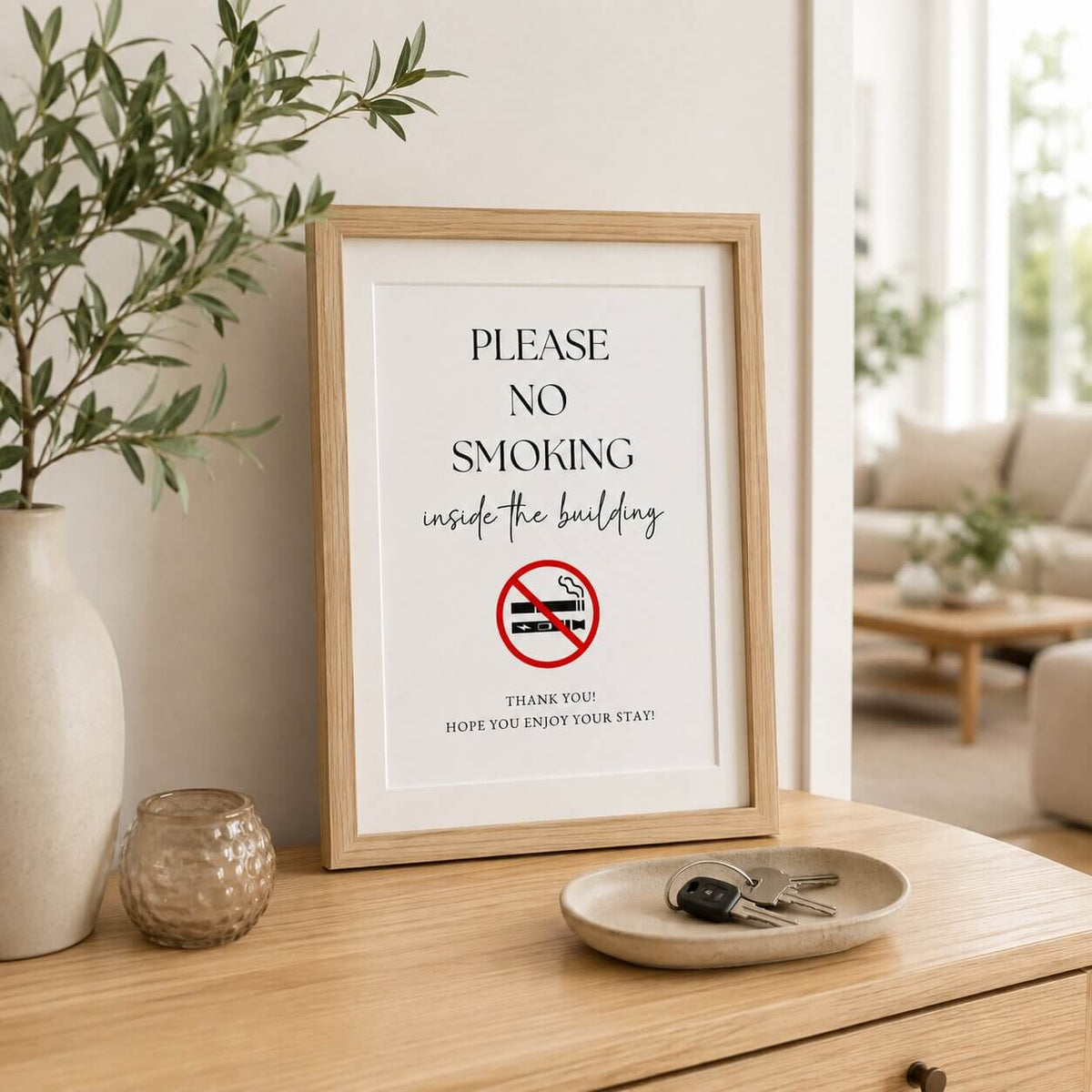 Framed no-smoking sign displayed beside a welcome book and property keys in a holiday rental