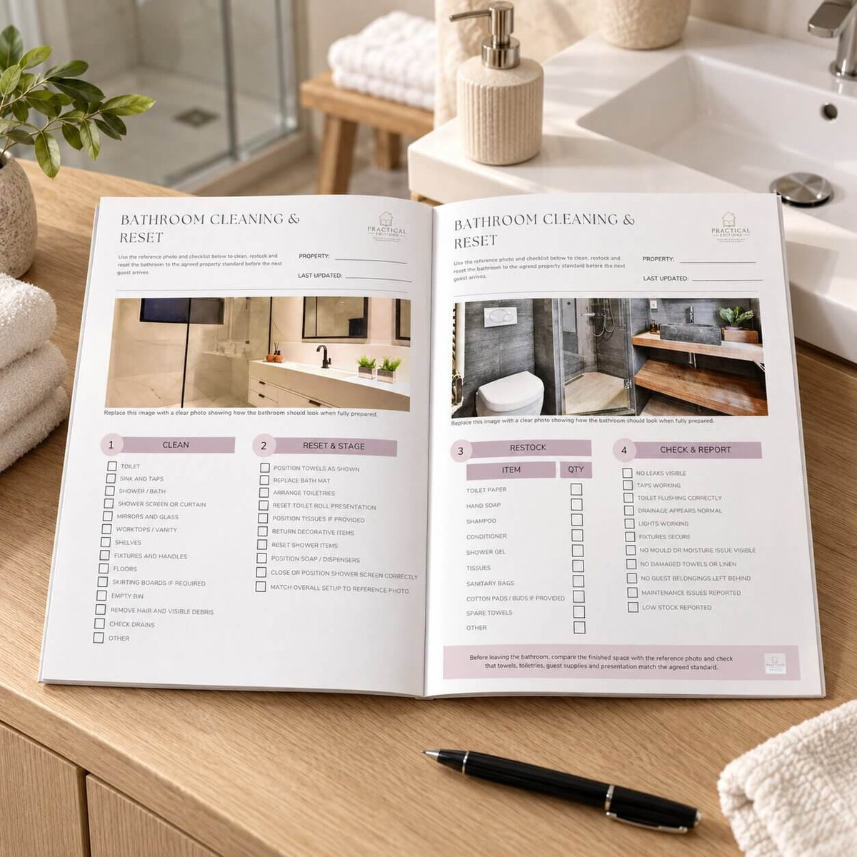 An open booklet titled 'Bathroom Cleaning & Reset' lies on a wooden bathroom counter, with a sink, soap dispenser, towels, and a black pen nearby. The pages show cleaning checklists and bathroom photos.