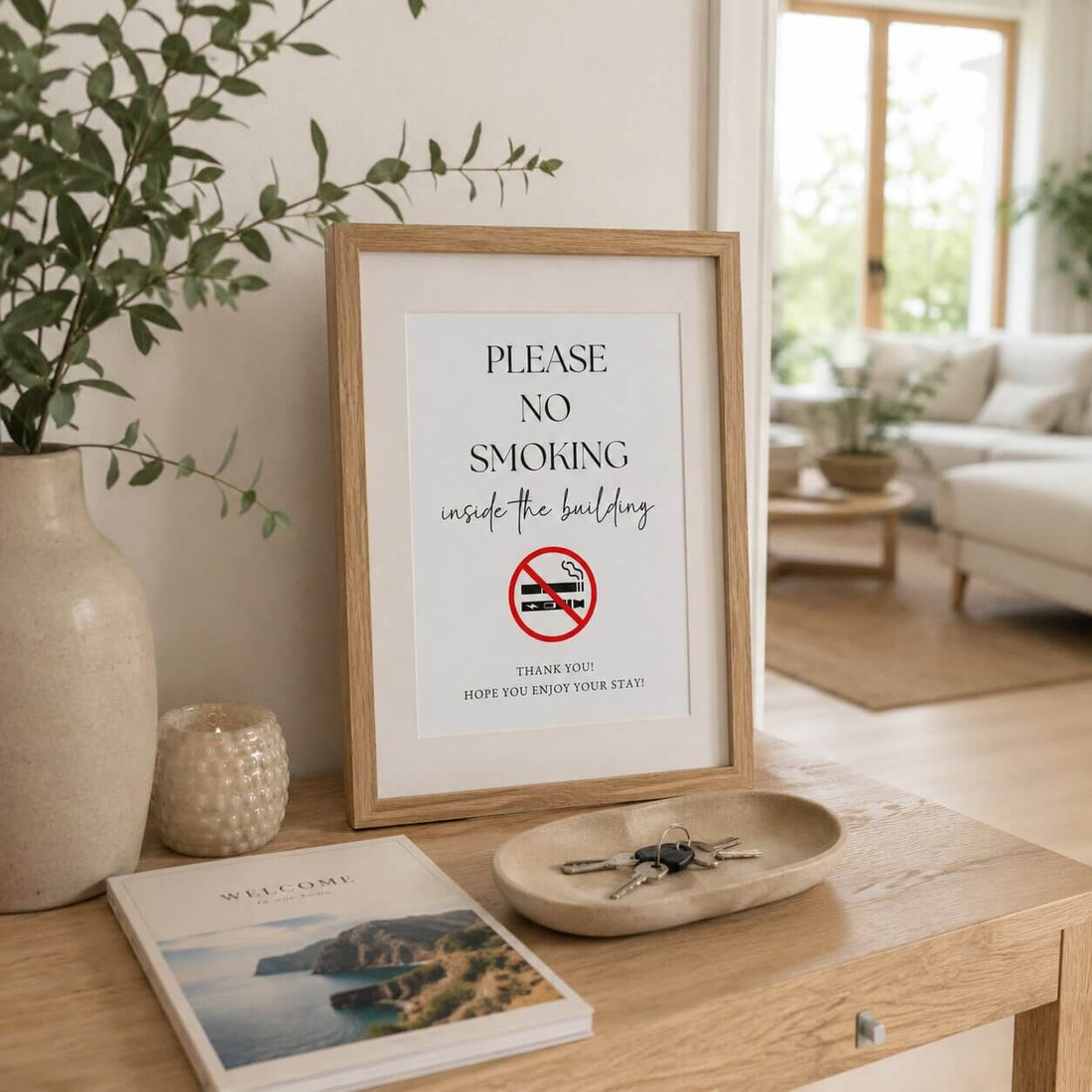 Framed no-smoking sign displayed beside a welcome book and property keys in a holiday rental